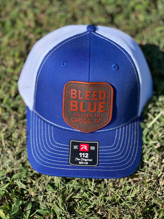 Blue and white Richardson 112 trucker hat with a Bleed Blue leather patch.