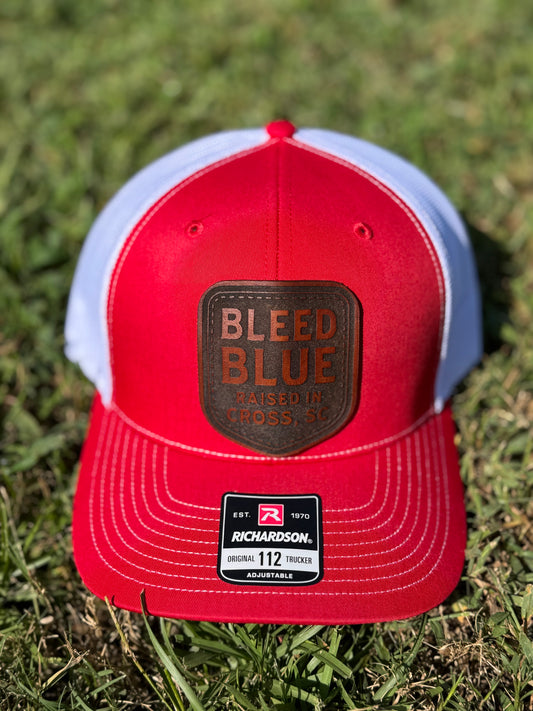 Red and white Richardson 112 trucker hat with a Bleed Blue leather patch.