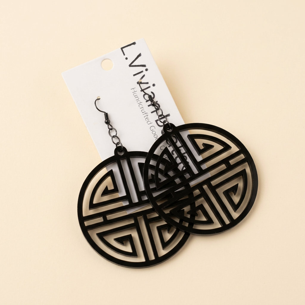 Black circular earrings with an ivory background